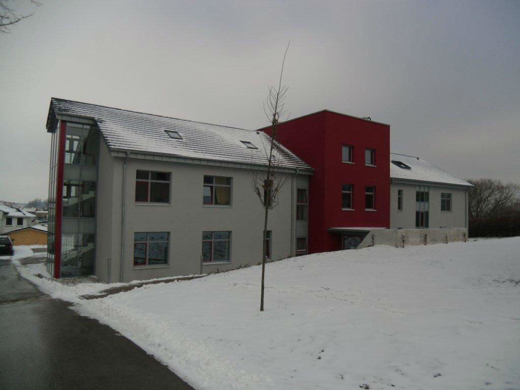 Modernes, Firmengebäude in weiß-roter Fassade im Winter